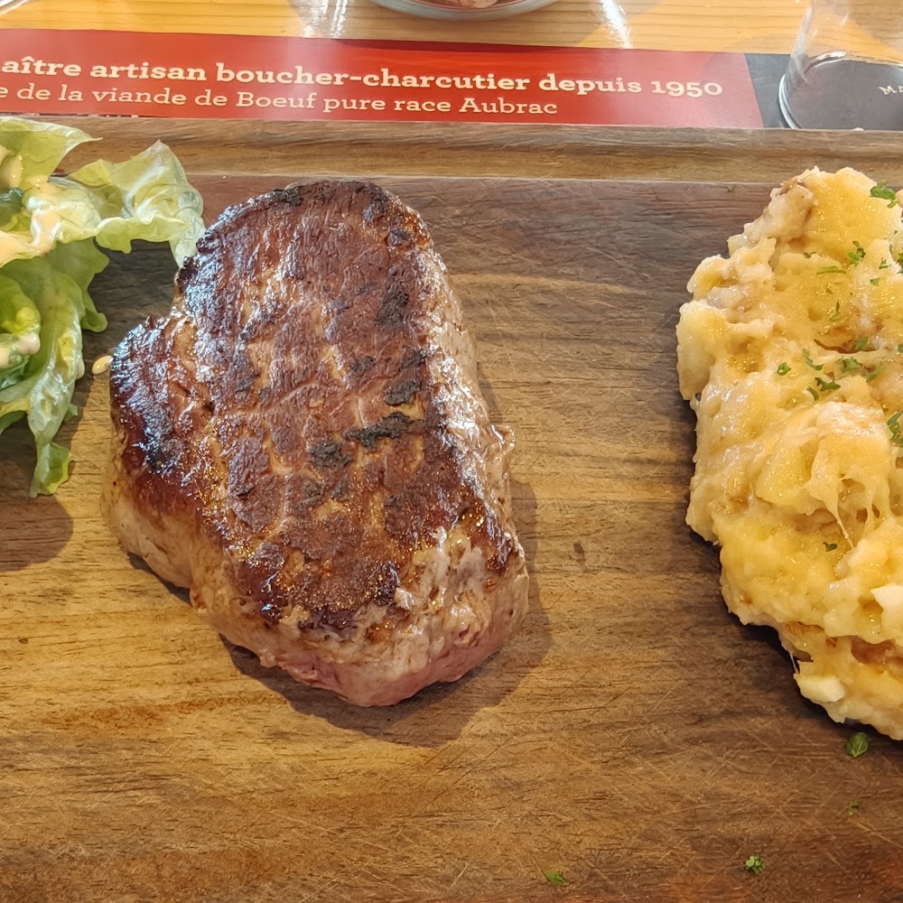 Une belle pièce de bœuf Aubrac servie avec sa truffade, sur planche de bois